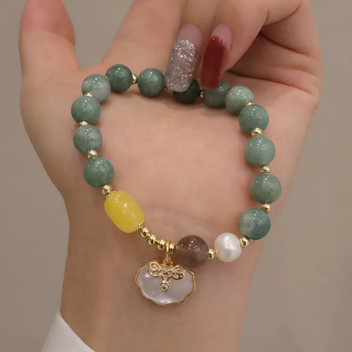 Green jade shell bracelet for women on a wrist, showing the natural stone colour and shell design detail.