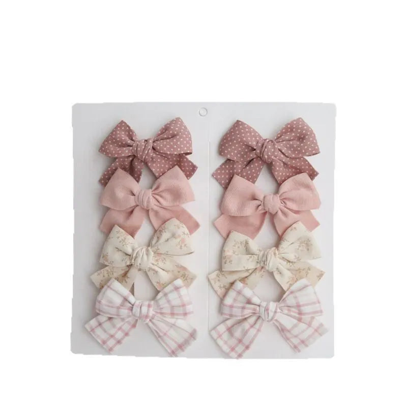 Set of children's cloth hair clips with a dovetail bow design in various colours.