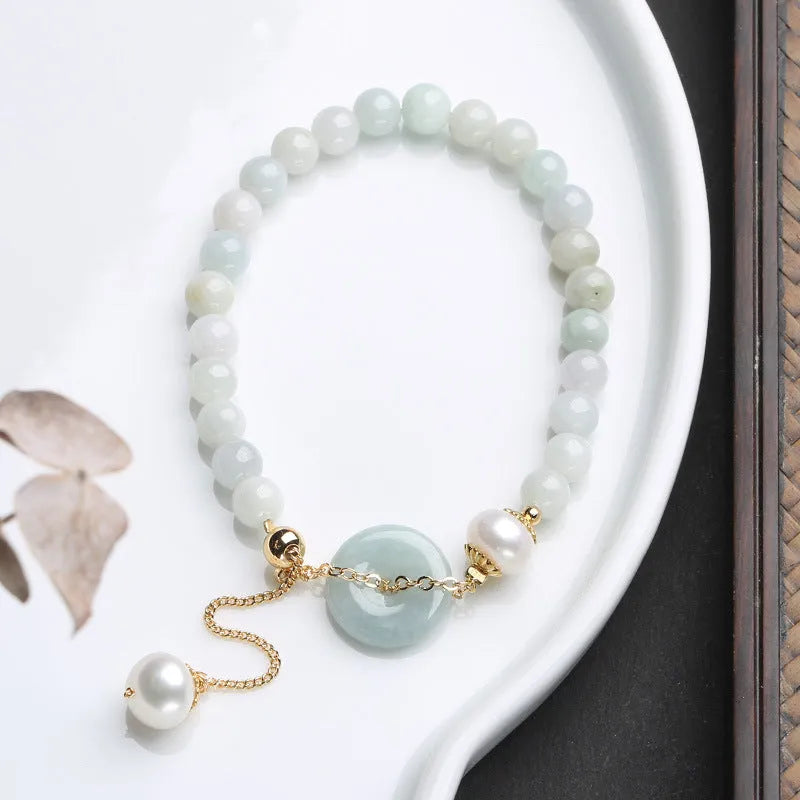 Natural emerald jade bracelet with pearl elements and peace buckle charm on adjustable cord
