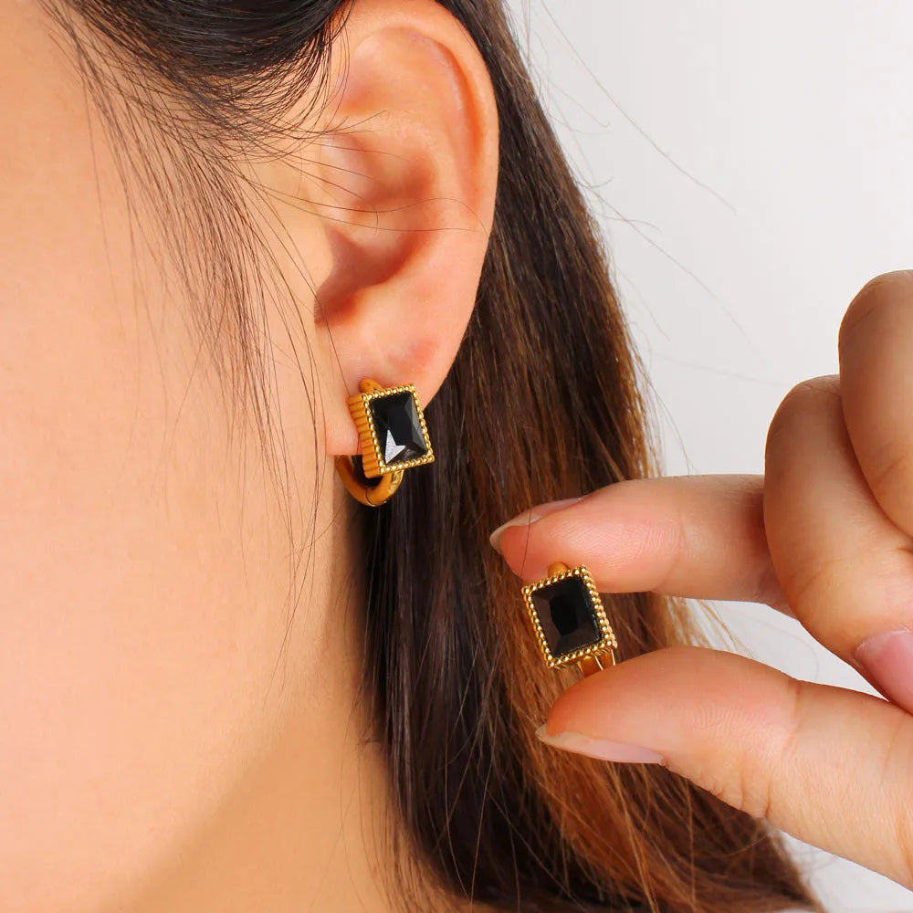 Square geometric stainless steel earrings with round ring details in white, black, or green electroplated finish.