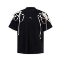Black loose fit short-sleeved t-shirt with padded shoulder detail and rivet ribbon accents