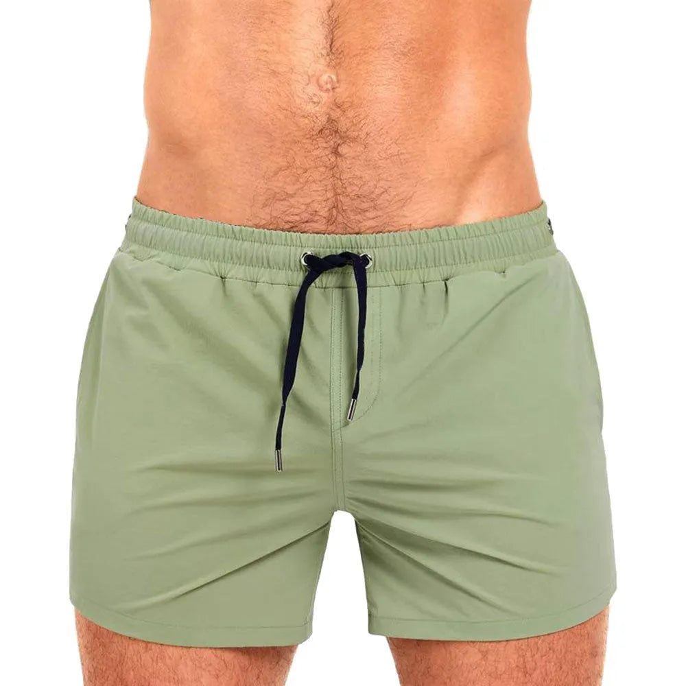 Men's solid colour polyester swimming shorts with mesh lining for sports and fitness.