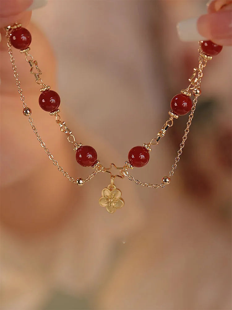 Red agate double layer women's bracelet with carved peach blossom and floral motifs.