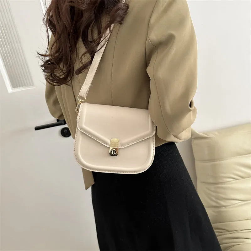 Men's soft black PU leather clamshell messenger bag in a horizontal square shape on a table.