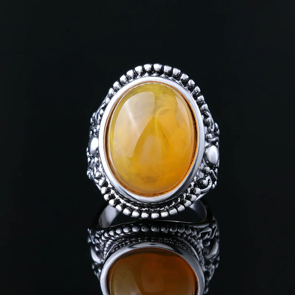 Geometric retro-style alloy ring in antique silver amber colour on a finger.