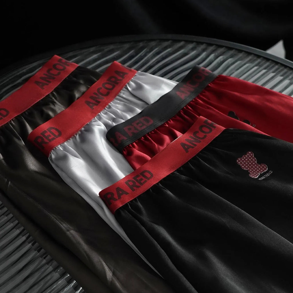 Solid colour men's polyester boxer briefs in black, shown with mid-waist design.