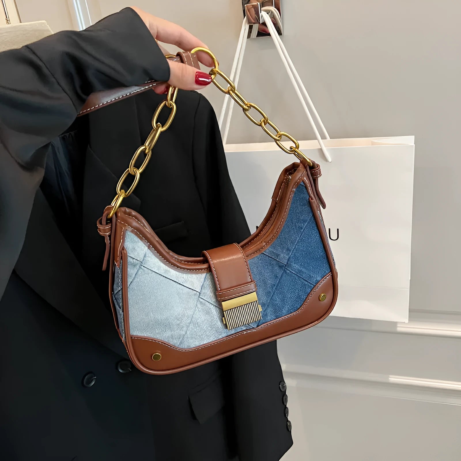 Brown denim women's bucket shoulder bag with chain strap and diamond mesh detail.
