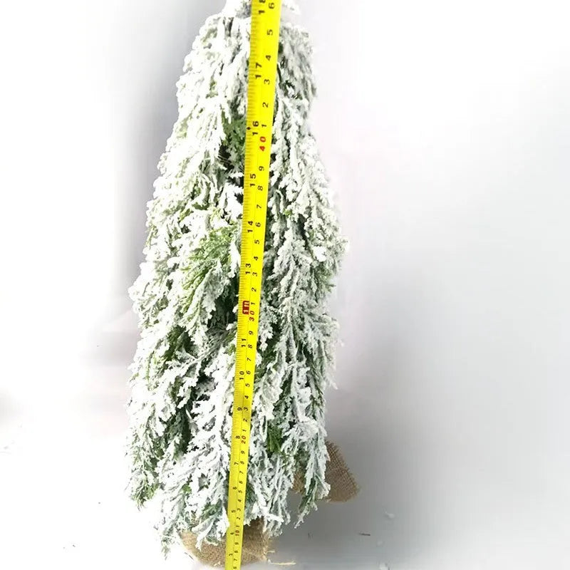 Small 24-inch artificial Christmas tree with LED lights and snow sprayer ornament on desktop