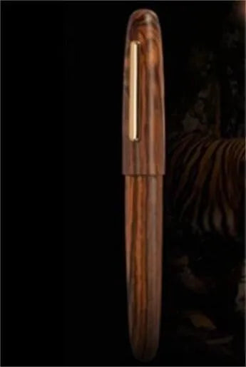 Wooden fountain pen with a rotating cap on a wooden desk, showing choice of rosewood and ebony bodies with different nibs.