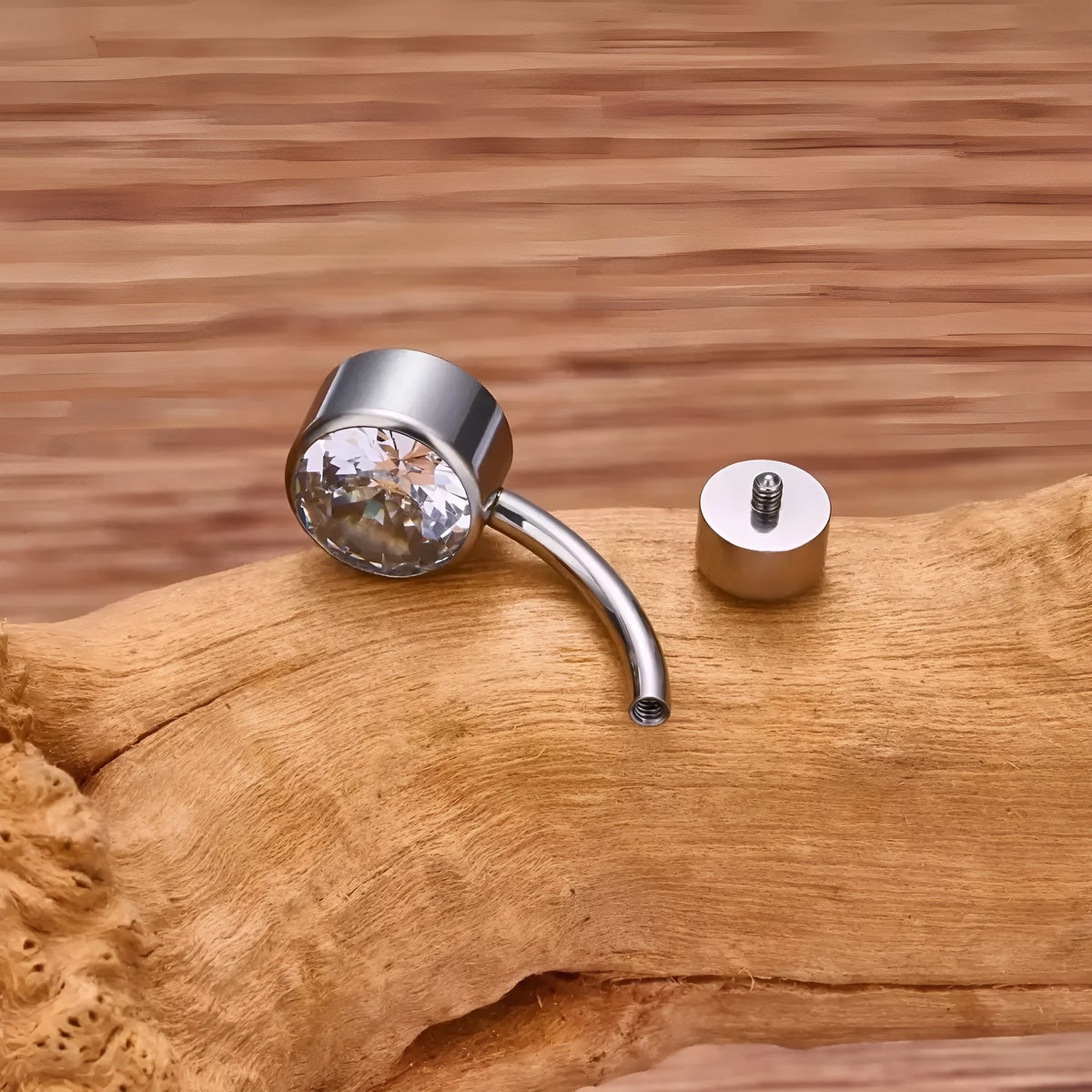 Titanium double-headed zircon navel stud in geometric shape on white background.