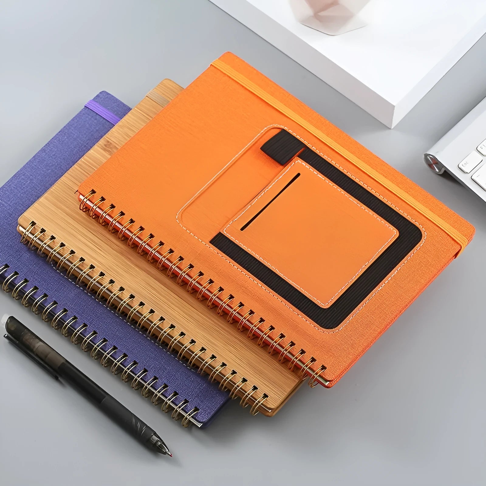 Erasable rock paper coil notebook with custom cover options, shown with a pen.