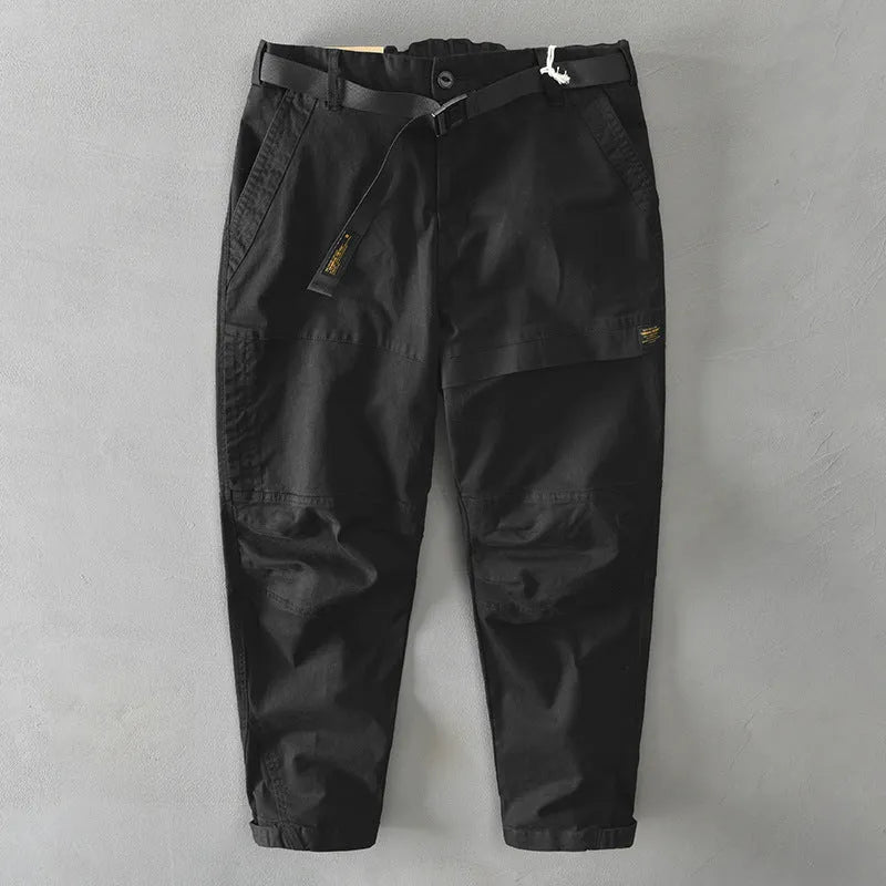 Men's loose-fit khaki cotton overalls with a mid waist and elastic fabric, shown laid flat.