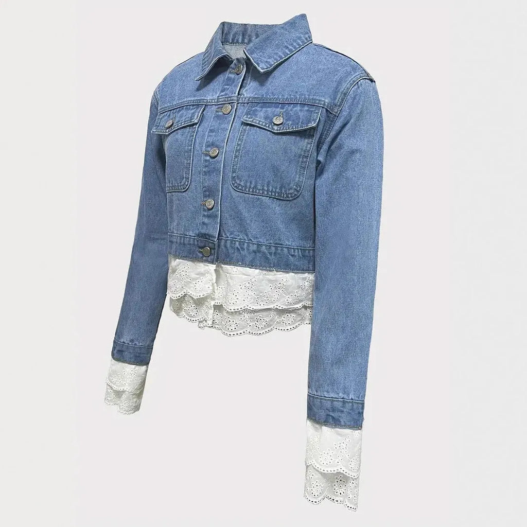 Blue women's denim jacket with decorative lace stitching detail on the front.