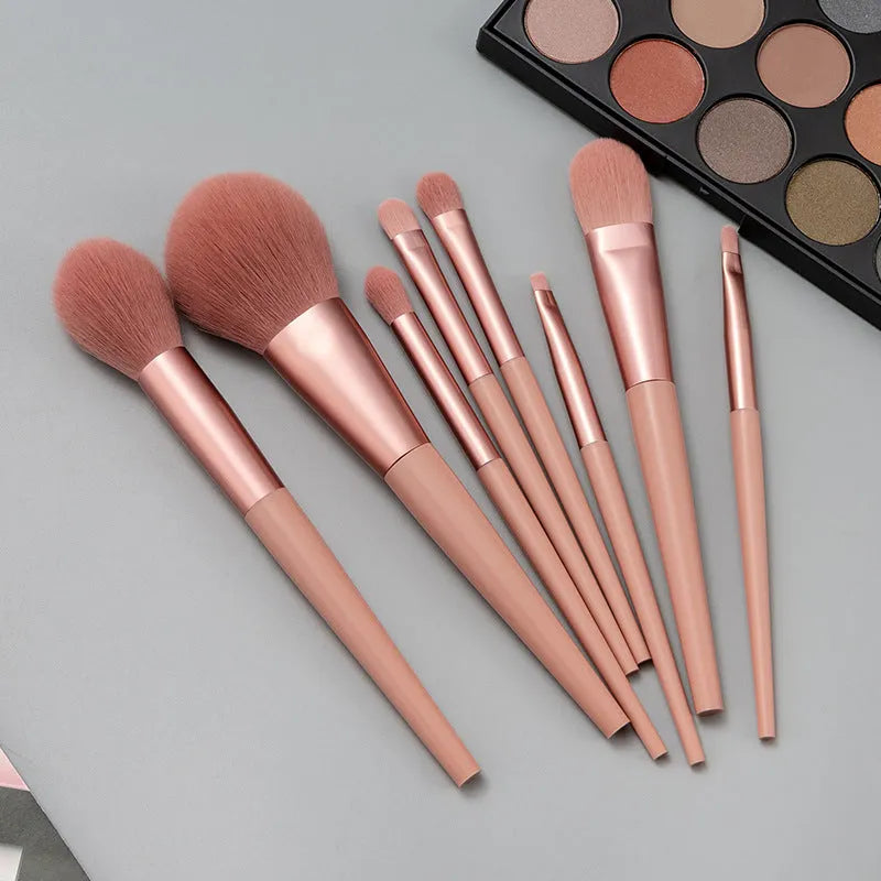 8-piece pink makeup brush set with man-made fibre heads and portable plastic handles, no bag included