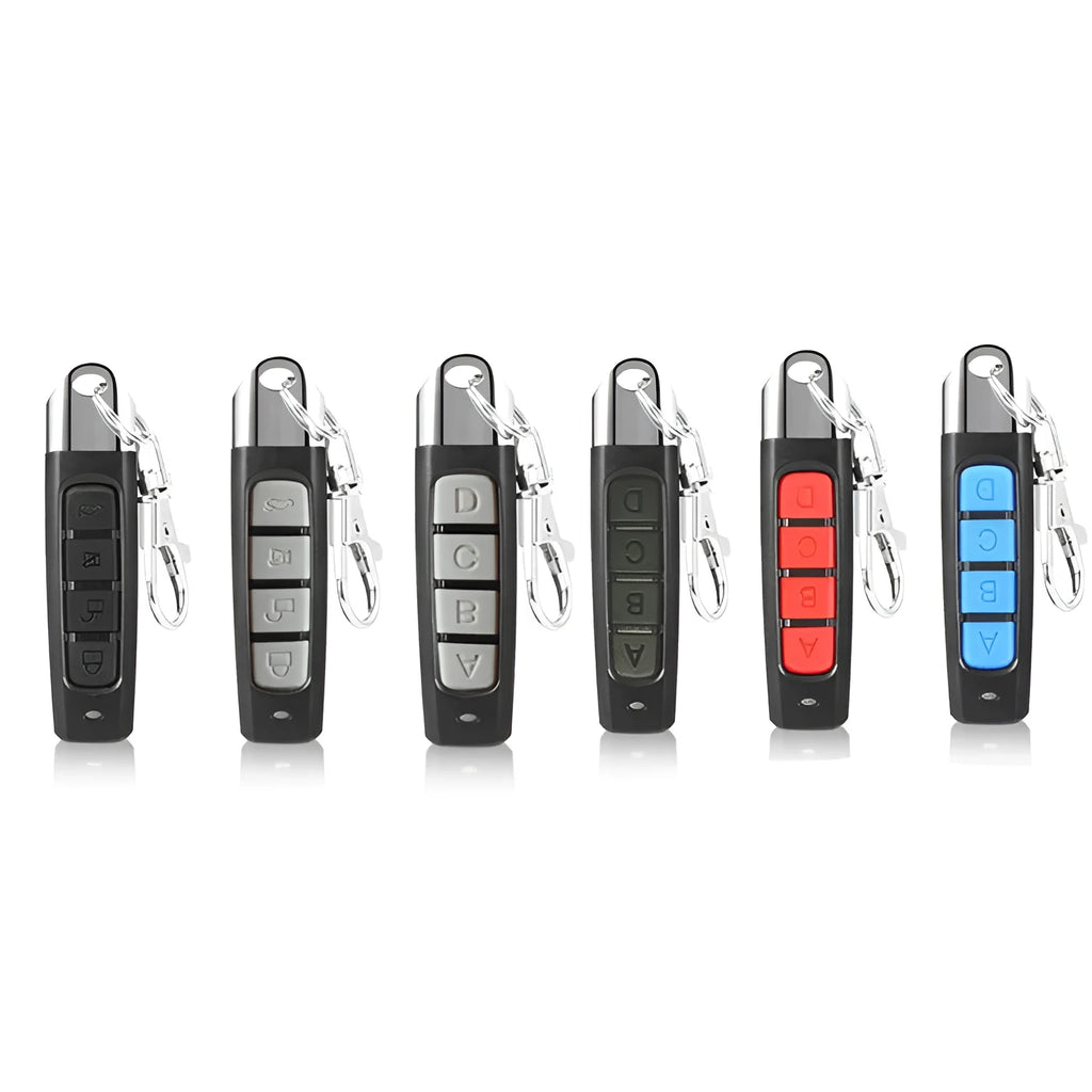 A black rolling door remote control duplicator unit showing its compact size and buttons for copy and test functions.