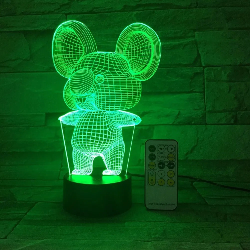 Koala-shaped LED night light with remote control on a bedside table, showing multiple colour options.