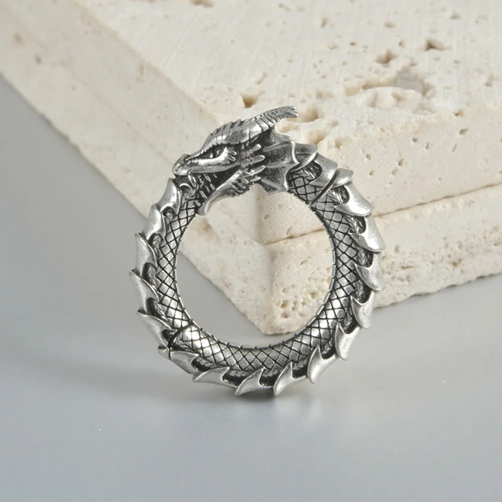 Close-up of large geometric dragon silhouette hollow out alloy earrings in antique silver finish.