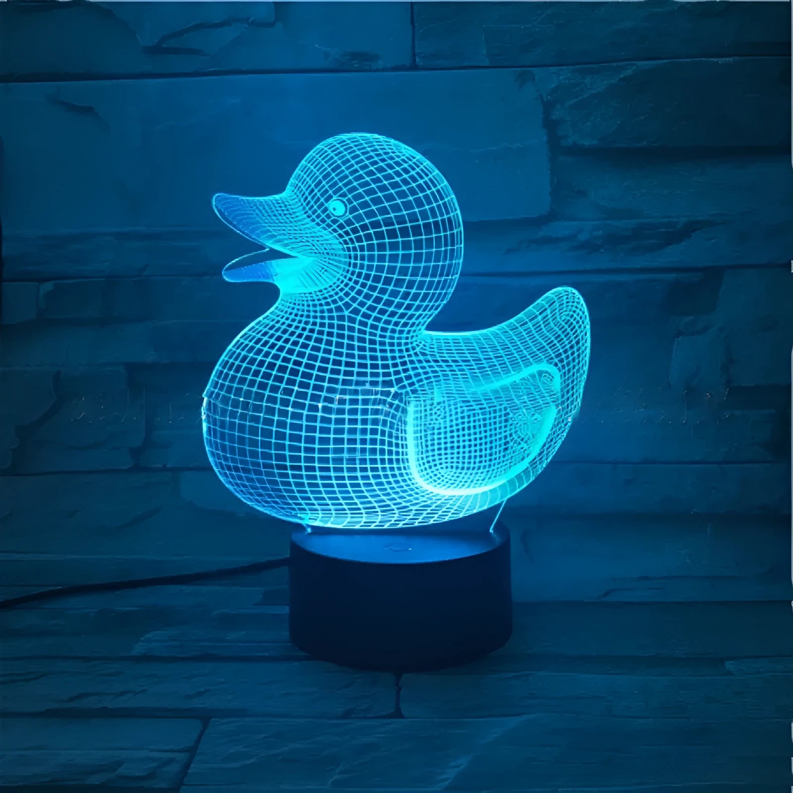 Little yellow duck 3D night light with remote control on a bedside table, showing colour change