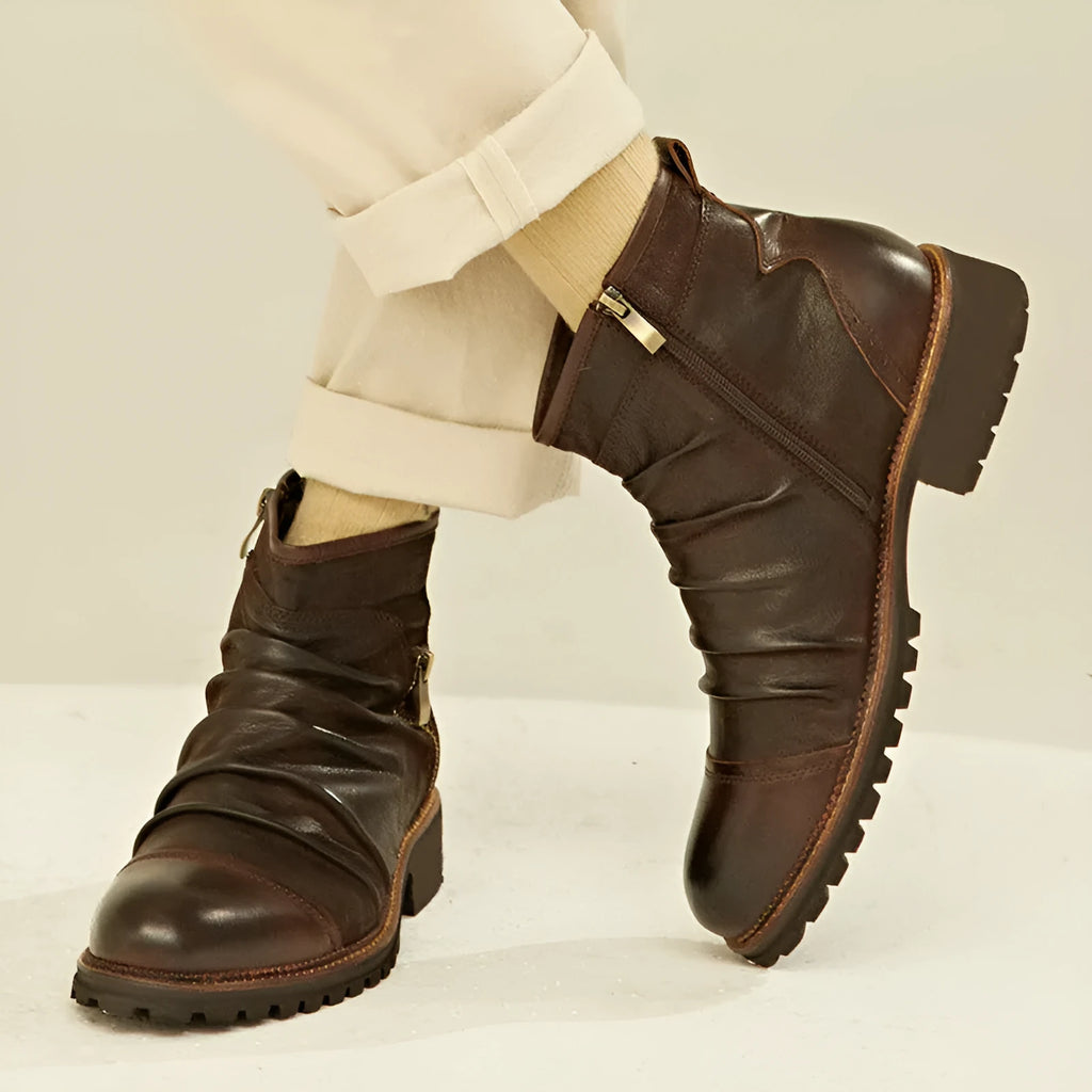 Men's brown side-zip cowboy Martin boots with round toe and horseshoe heel on a wooden background.