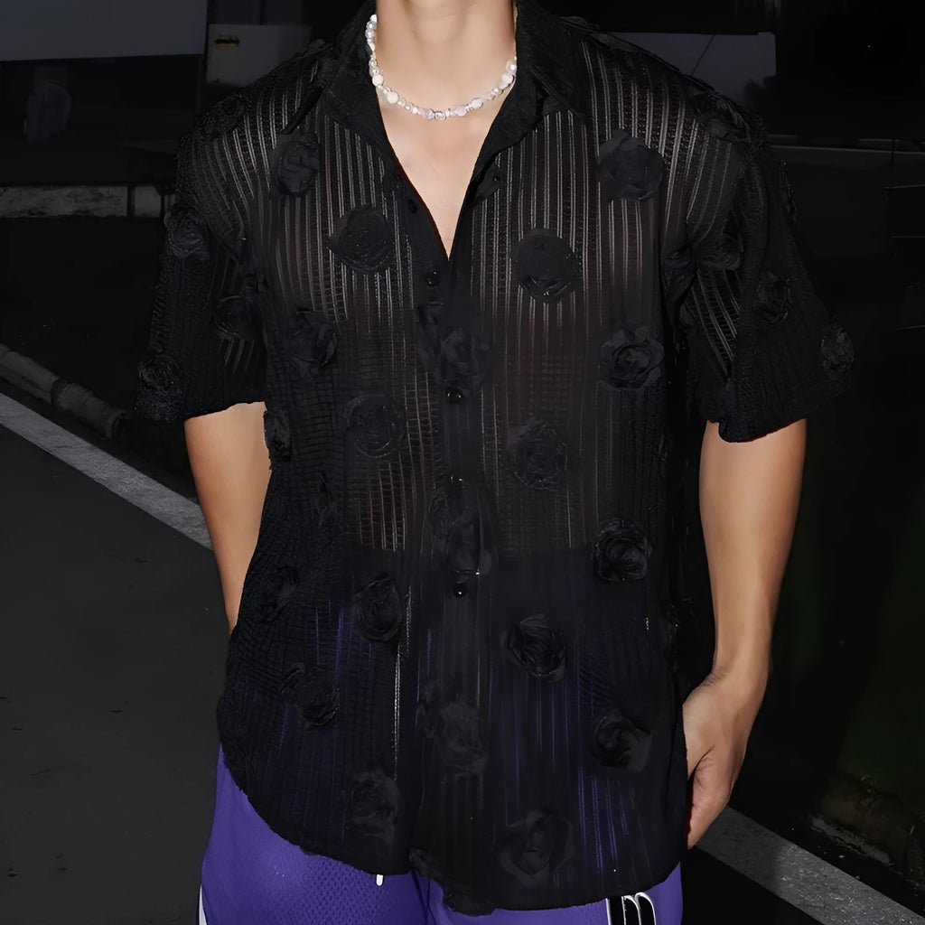 Man wearing a loose-fit black short-sleeved shirt with a large white three-dimensional floral print.