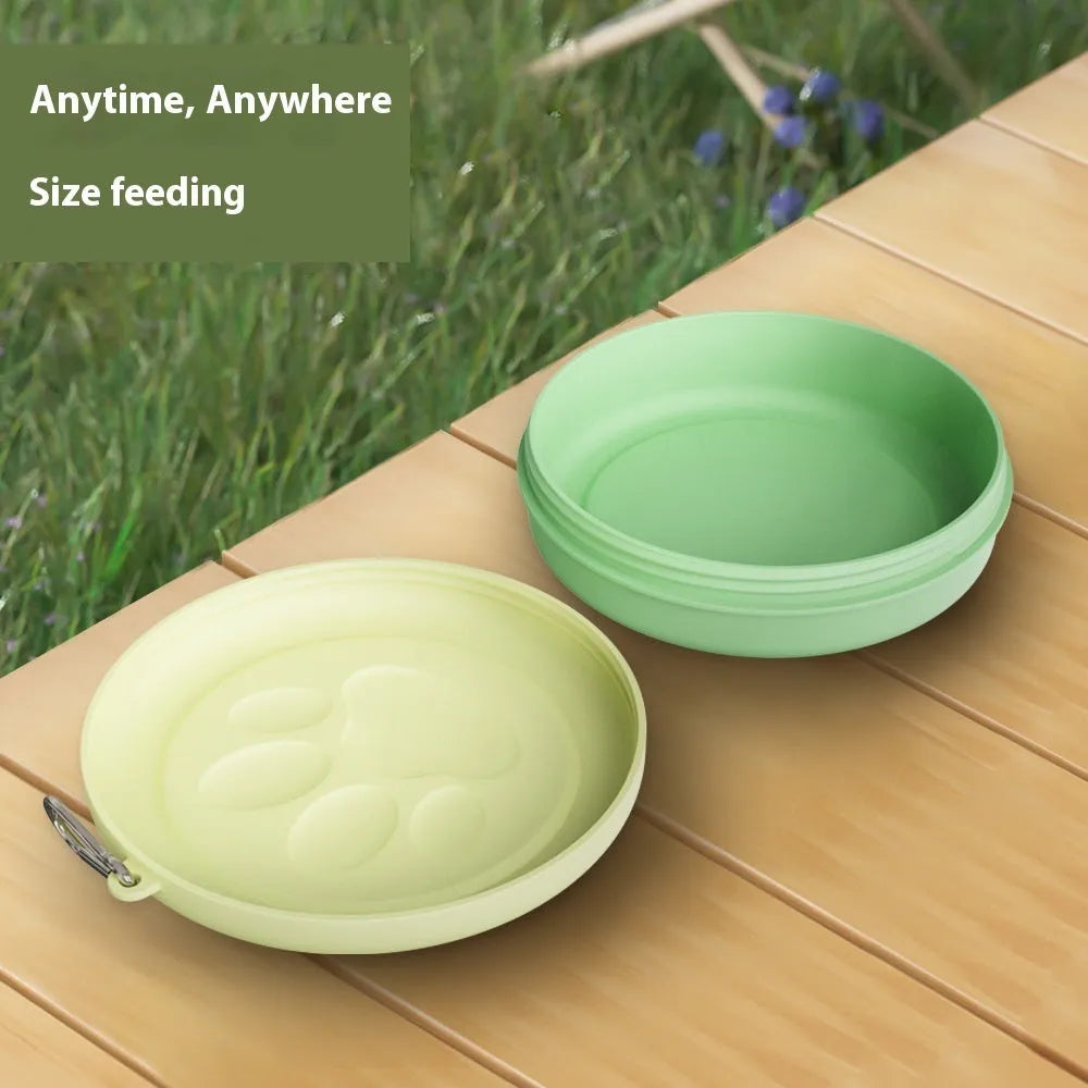 Collapsible portable dog bowl in light green with a separate snack box compartment, shown in its open state.