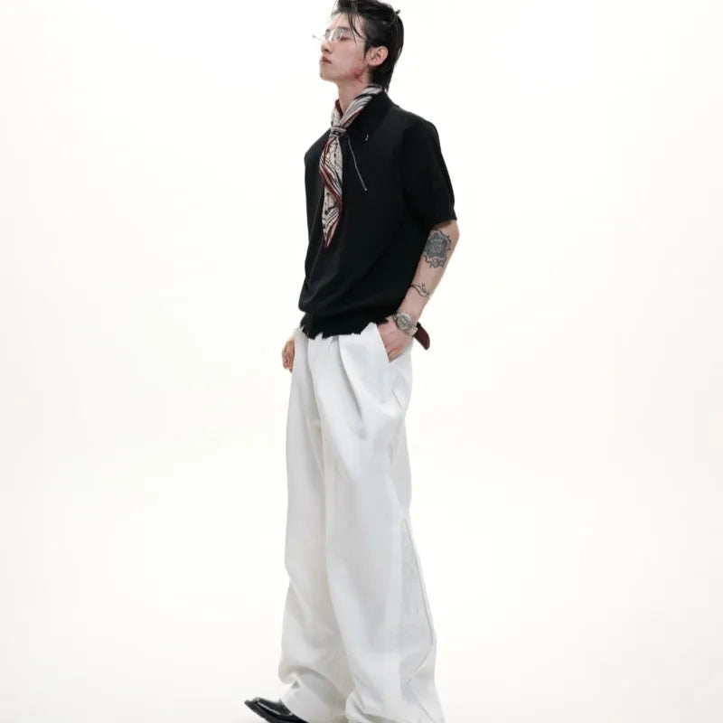 Man modelling a slim-fit black knitted polo shirt with a diagonal oblique zip and lapel collar.