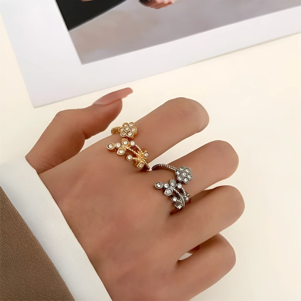 Close-up of a women's open ring with detailed floral leaf engraving, shown in gold colour finish.