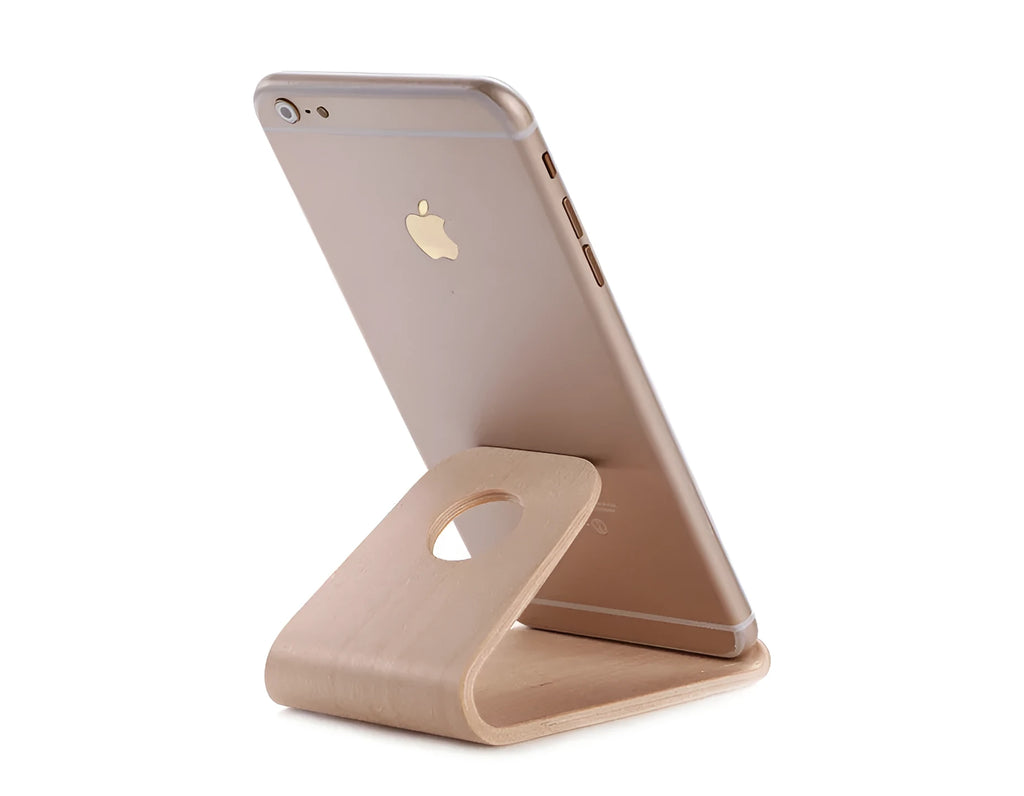 Wooden phone charging stand for iPhone in walnut or white maple finish on a desk.