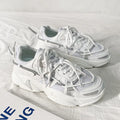 Men's white Korean style platform dad shoes with front lace-up closure on a neutral background.