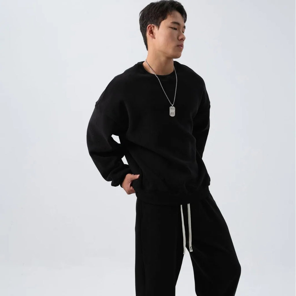 Men's black polar fleece sports suit with crew neck coat and padded trousers on a hanger