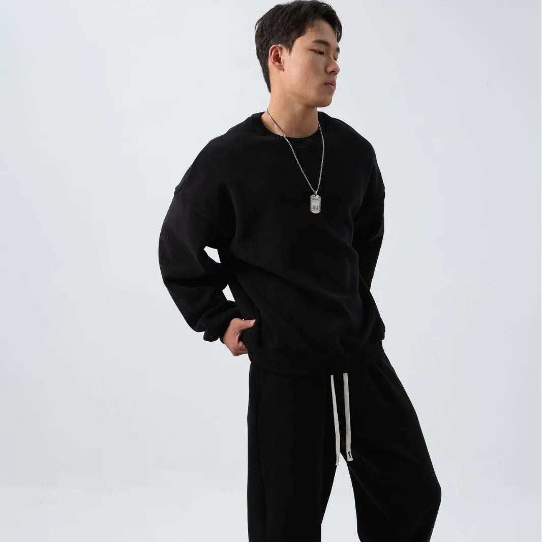 Men's black polar fleece sports suit with crew neck coat and padded trousers on a hanger