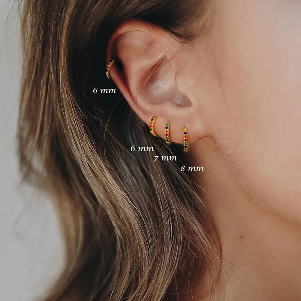 Gold, rose gold, and silver circle stud earrings with a perforated geometric design and zircon detail.