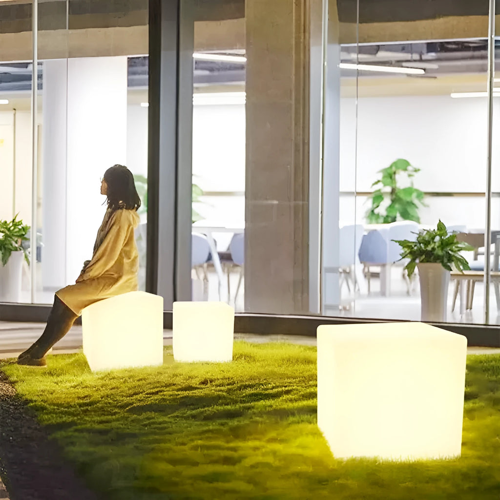 A modern square white LED cube stool light for outdoor garden use.
