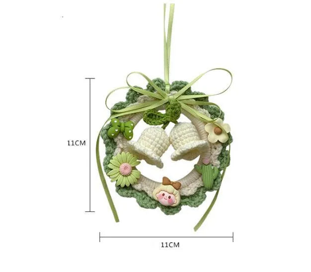 Green woven wool bell orchid floral car pendant hanging from a rear-view mirror.