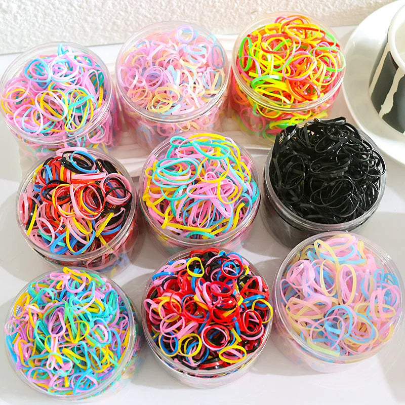 Pack of small, colourful TPU elastic hair bands for babies and toddlers in a reusable container.