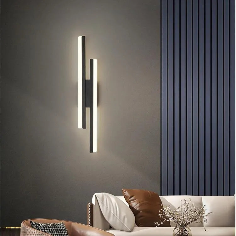 Scandinavian minimalist LED wall light with an acrylic shade on a black arm, mounted on a light-coloured wall.