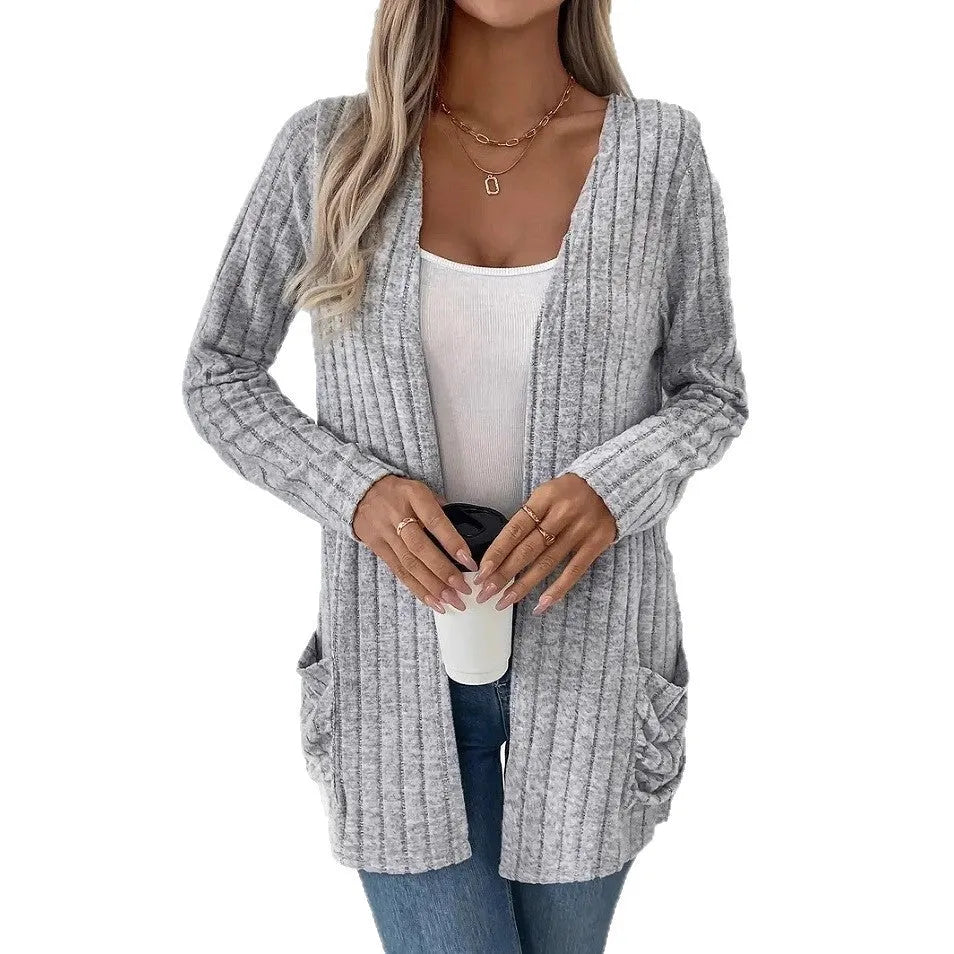 Loose fit grey cardigan with long sleeves and side pockets on a hanger.