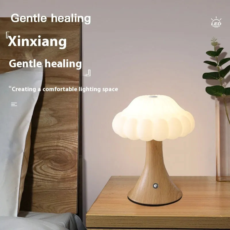 Mushroom-shaped touch control night lamp in wood grain colour on a table.