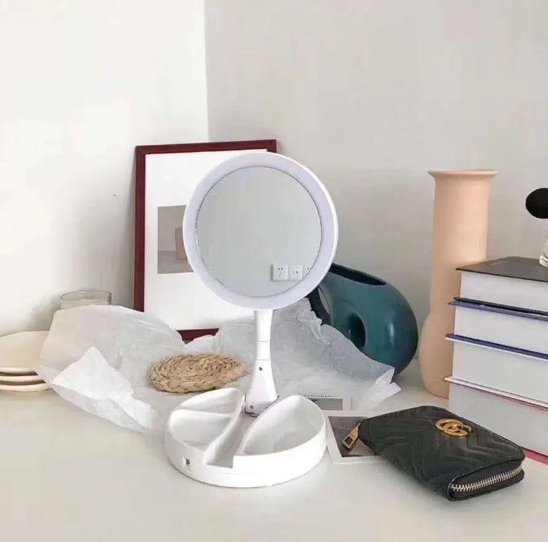 White foldable double-sided LED vanity mirror with built-in storage compartments and USB cable.