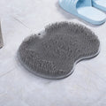 Orange silicone bath brush with suction cups on back and hundreds of small bristles for cleaning feet and back.