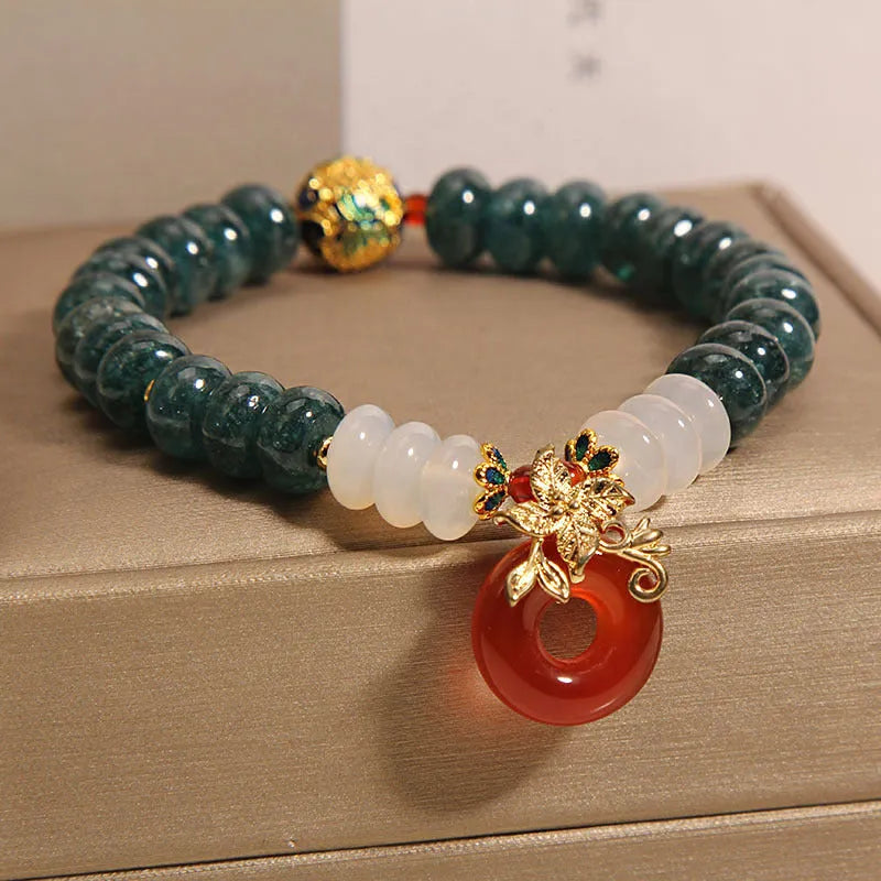 Women's blue water jade and red agate bracelet with peace buckle closure and rhinestone details