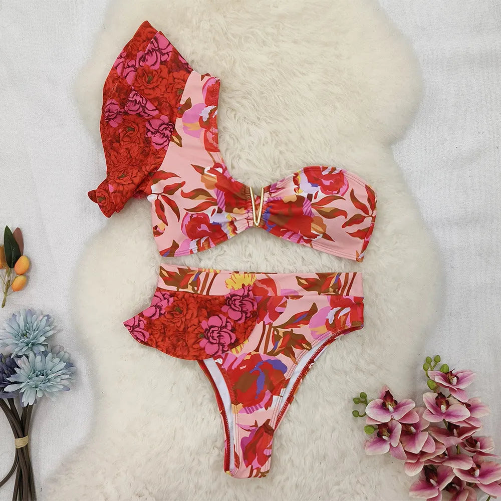 Women's pink floral print one-shoulder ruffled swimsuit with high-waisted bikini briefs.