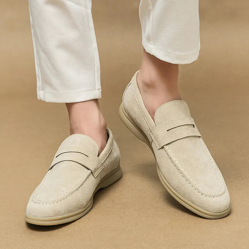 Men's beige leather slip-on casual shoes with a round toe and rubber sole on a neutral background.