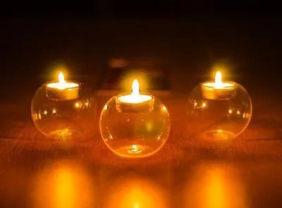 Clear hollow glass spherical candle holder in European style on a table.