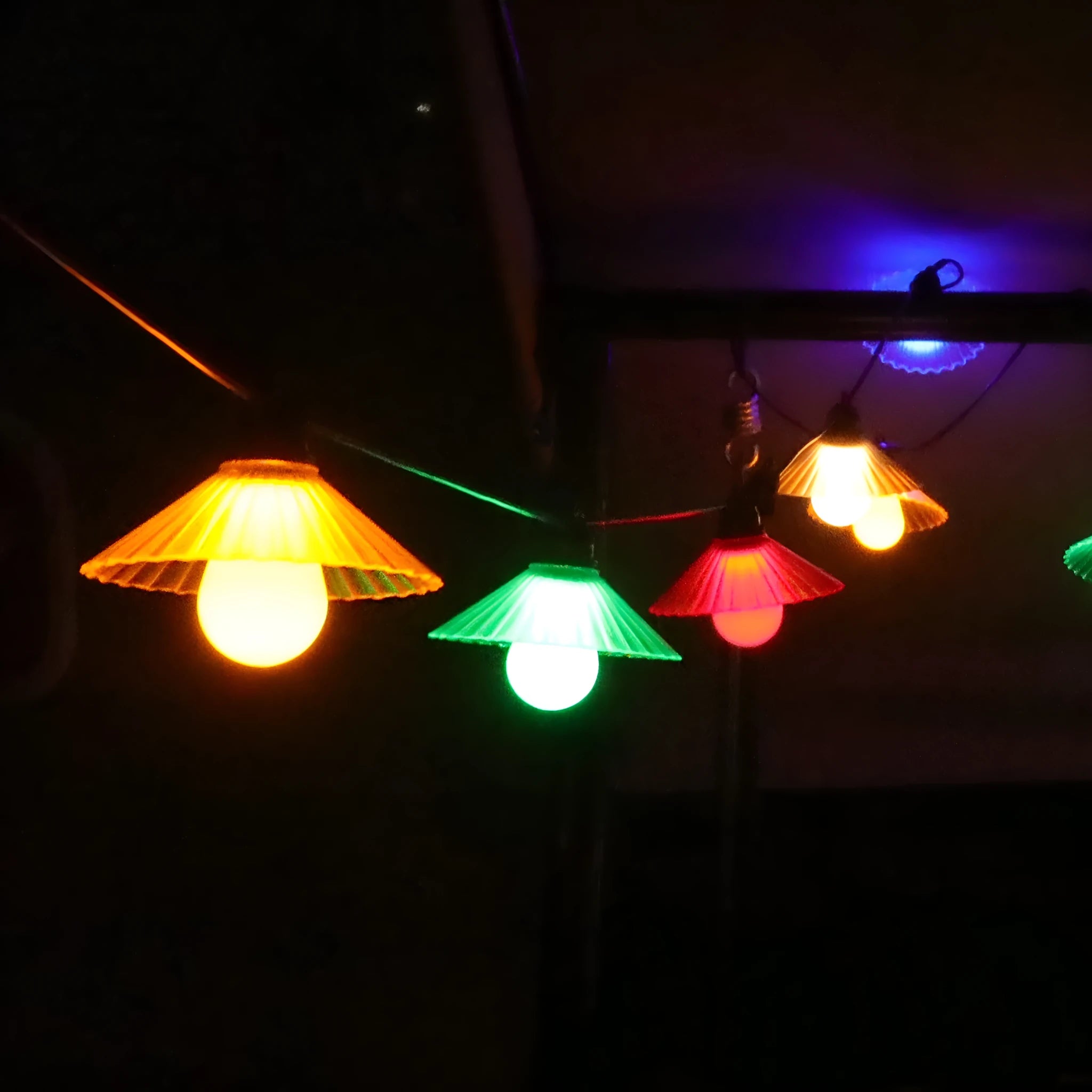 Outdoor LED string lights with flower-shaped globes shown in warm white and multi-colour settings.