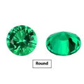 Selection of polished cultivated emerald gemstones in various cuts and sizes on a dark background.