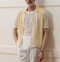 Yellow asymmetric hollow-out short-sleeved polo shirt on a hanger