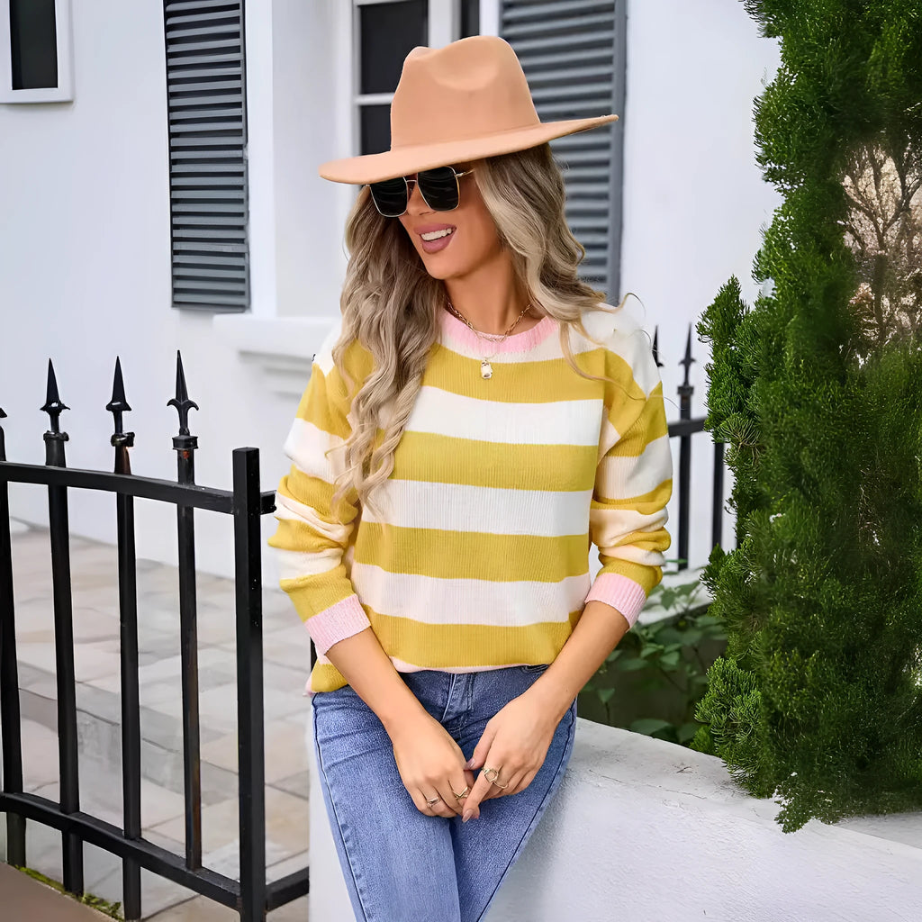 Women's loose fit long sleeve acrylic sweater in blue, showing round neck and stripe detail.