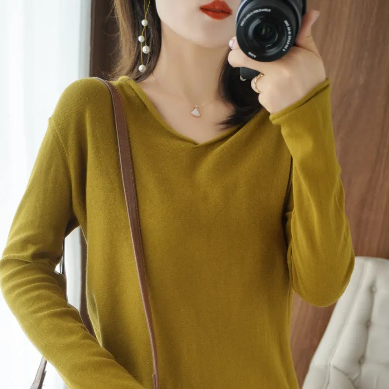 Women's turmeric V-neck long sleeve knitwear top laid flat.