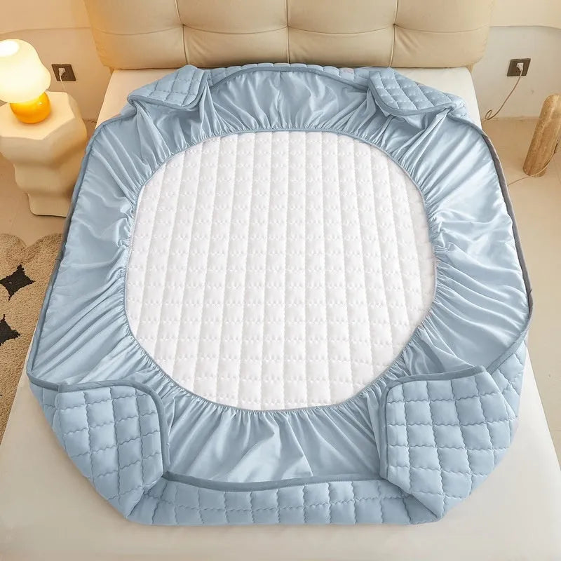 Blue washed cotton waterproof fitted sheet with elasticated corners on a mattress.